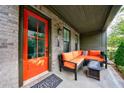 Relaxing front porch with cozy seating and a bright orange front door at 6645 Cortland Walk, Alpharetta, GA 30005