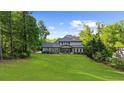 Expansive backyard featuring lush lawn, mature trees and a well-maintained two-story home at 885 Old Peachtree Ne Rd, Lawrenceville, GA 30043