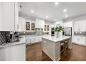 Modern kitchen with white cabinetry, a spacious island with seating, granite countertops, and stainless steel appliances at 885 Old Peachtree Ne Rd, Lawrenceville, GA 30043