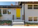 Close-up of the house with a bright yellow front door, contrasting the white brick and black trim at 2103 Columbia Dr, Decatur, GA 30032