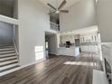 Bright open-concept living room features high ceilings, wood floors and seamless flow into modern kitchen with staircase at 479 Rising Sun Path, Lawrenceville, GA 30043