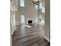Bright living room featuring high ceilings, fireplace, wood floors, seamless flow into kitchen, and plenty of natural light at 479 Rising Sun Path, Lawrenceville, GA 30043