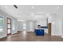 Bright open-concept space with modern lighting, many windows, and kitchen island with blue cabinets at 3312 Mill Forest Dr, Conyers, GA 30094