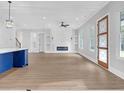 Open-concept living room with modern fireplace, many windows, stylish lighting, and blue kitchen island at 3312 Mill Forest Dr, Conyers, GA 30094