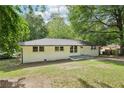Charming painted brick home with a well-maintained lawn and mature trees at 5729 Jefferson Ave, Forest Park, GA 30297