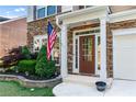 Inviting front entryway with a classic wood door, stone accents, and meticulous landscaping at 971 Reap Lane, Lawrenceville, GA 30043