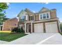 Charming two-story home showcasing a stone facade, a two-car garage, and manicured landscaping at 971 Reap Lane, Lawrenceville, GA 30043