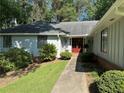 Inviting entrance with a red double door, pathway, and manicured landscaping enhances this home's curb appeal at 125 Fortuna Ct, Roswell, GA 30075