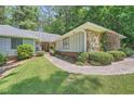 Charming single-story home with stone accents, a well-kept lawn, and a pathway leading to the entrance at 125 Fortuna Ct, Roswell, GA 30075