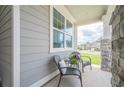 Inviting front porch with seating area and stone pillars, providing a cozy outdoor space at 213 Hickory Bluffs Pkwy, Canton, GA 30114