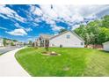Well-maintained lawn surrounds the home, with mature trees in the background, and sidewalks at 213 Hickory Bluffs Pkwy, Canton, GA 30114