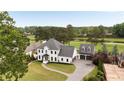 Aerial view of an elegant home on a golf course with a long driveway to a three-car garage at 2211 Lattimore Farm Nw Dr, Kennesaw, GA 30152