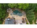 Aerial view of a backyard oasis with a freeform pool, spa, fire pit, lounge areas, and lush landscaping at 120 Burford Holw, Alpharetta, GA 30022