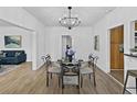 Dining room with chandelier, table set for four, wood flooring, and open to the living room at 2896 Toney Dr, Decatur, GA 30032