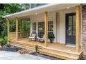 Inviting front porch featuring rocking chairs, wood floors, and natural wood columns, perfect for relaxing at 5560 Pilgrim Point Ext, Cumming, GA 30041