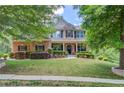 Charming two-story home with brick and stone accents, landscaped yard, and inviting front porch at 5960 Bridge Stone Ct, Cumming, GA 30028