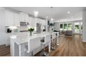 Spacious kitchen with white cabinets, stainless appliances, large island, and open layout to living room at 3982 Carver Cir, Doraville, GA 30360