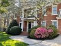 Charming brick home featuring mature landscaping with colorful azaleas and a covered porch at 4649 Equestrian Way, Atlanta, GA 30338