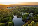 An aerial view of the home at 2334 Fisher Drive surrounded by lush trees and overlooking a serene lake at 2334 Fisher Dr, Loganville, GA 30052