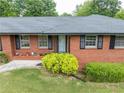 Close up of a charming red brick home with lush green landscaping and mature shrubbery at 3089 Ranlo Dr, Atlanta, GA 30340