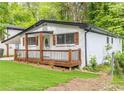 Inviting home with covered front porch, white painted brick and black trimmed windows at 493 Woods Nw Dr, Atlanta, GA 30318