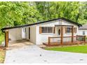 This home offers a inviting front porch, carport, and newly painted white brick at 493 Woods Nw Dr, Atlanta, GA 30318