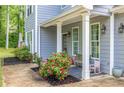 Inviting covered front porch with seating and blooming roses adds charm at 5652 Burruss Rd, Cumming, GA 30028