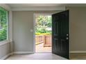 Welcoming entryway featuring a black front door, light-filled sidelight window, and outdoor deck view at 788 Fayetteville Se Rd, Atlanta, GA 30316