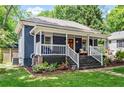 Angle view of a lovely blue home featuring a front porch with white railings and a well-manicured lawn at 2647 Forrest Nw Ave, Atlanta, GA 30318