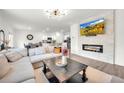Cozy living room with a stone fireplace, modern light fixture and open floor plan at 3828 Ramsay Pass, Loganville, GA 30052