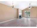 Bright living room features a fireplace, ceiling fan, chandelier, and large window at 5805 Eagles Feather Ln, Riverdale, GA 30274