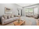 Inviting living room with natural light, neutral tones, and comfortable seating arrangement at 6297 Polar Fox Ct, Riverdale, GA 30296