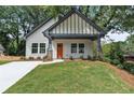 Inviting craftsman home with a bright orange front door, covered porch, and pristine landscaping at 2621 Oldknow Nw Dr, Atlanta, GA 30318