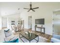 Sunlit living room boasts vaulted ceilings, sleek fan, and flows into kitchen and dining at 2621 Oldknow Nw Dr, Atlanta, GA 30318