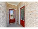Inviting front porch featuring brick accents and a striking red door at 736 Ocmulgee Xing, Locust Grove, GA 30248