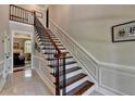 Elegant staircase with wood and iron railing, complemented by wainscoting, adds architectural detail at 1830 Hadfield Blvd, Roswell, GA 30075