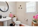 Cozy powder room with pedestal sink, decorative mirror, and stylish accents creates a welcoming space at 245 Tapestry Dr, Mcdonough, GA 30252
