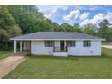 Inviting single-story home with a covered porch, updated windows, and a lush green lawn at 405 Emory St, Oxford, GA 30054