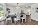 Bright dining room featuring hardwood floors, a modern chandelier, and a large window overlooking the yard at 529 Greystone Trl, Marietta, GA 30068