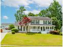 Beautiful home showcasing a lush green lawn and a welcoming front porch, complete with classic shutters at 855 Madison Chase Way, Lawrenceville, GA 30045