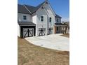 Front facade featuring a well-manicured lawn and a three-car garage with custom doors at 222 Silvercrest Dr, Acworth, GA 30101