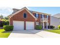 Two-story brick home featuring a two-car garage and a covered front entrance at 310 Hammersmith Dr, Suwanee, GA 30024
