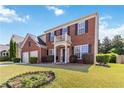 Inviting two-story brick home featuring a well-kept lawn and a spacious two-car garage at 310 Hammersmith Dr, Suwanee, GA 30024