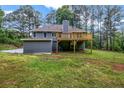 Backyard featuring an elevated wooden deck, large yard, and mature trees at 3232 Watson Mill Dr, Loganville, GA 30052