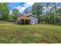 Backyard view showing a large lawn, wooded area, and a wooden deck at 3232 Watson Mill Dr, Loganville, GA 30052
