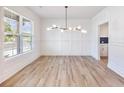 Bright dining room featuring modern light fixture and stunning wood-look floors at 4191 Hosch Reserve Dr, Buford, GA 30519