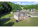 Aerial view of a brick front home with a lush lawn and landscaped garden in a friendly neighborhood at 423 Blackbird Way, Hampton, GA 30228