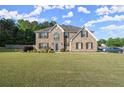 Beautiful two-story brick home featuring a spacious front yard and inviting curb appeal at 423 Blackbird Way, Hampton, GA 30228