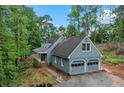 Charming home with attached garage and covered porch surrounded by mature trees on a sunny day at 61 Sherwood Se Ln, Marietta, GA 30067