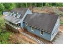 View of charming house with attached two-car garage and a covered porch. House is surrounded by trees at 61 Sherwood Se Ln, Marietta, GA 30067